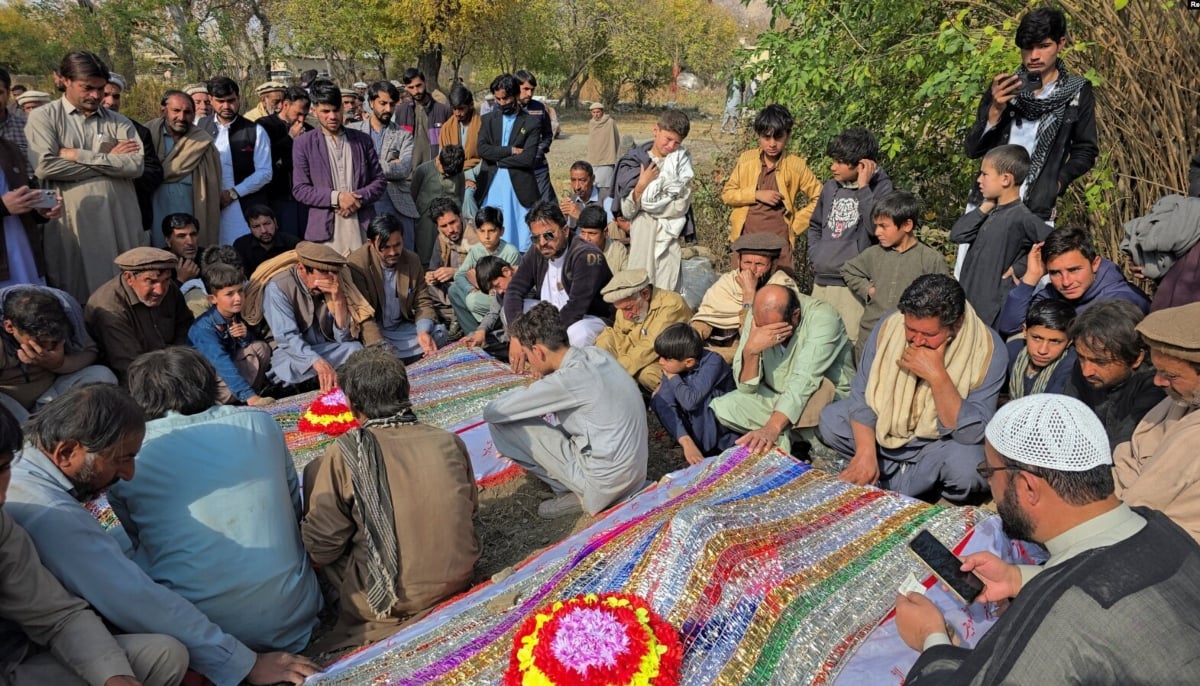 People mourn over the graves of relatives who were killed in fresh sectarian violence in Kurram on November 22, 2024. — Reuters