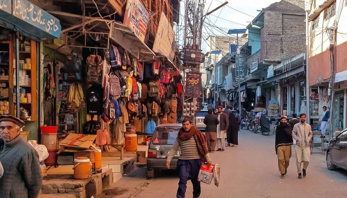 This photograph taken on December 3, 2024, shows local residents walking across a market reopened after sectarian clashes in Parachinar, Khyber Pakhtunkhwa province. — AFP