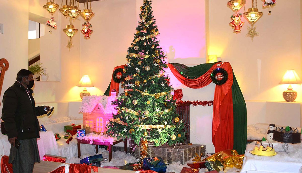 A man viewing Christmas tree installed at local hotel in Quetta amid Christmas festivities on December 24, 2024.— INP