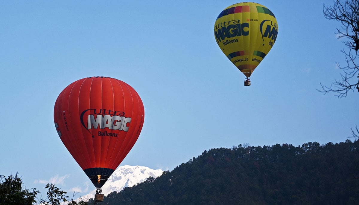 Two hot air balloons go up in sky during the international festival at Pokhara in Nepal on December 25, 2024. — AFP