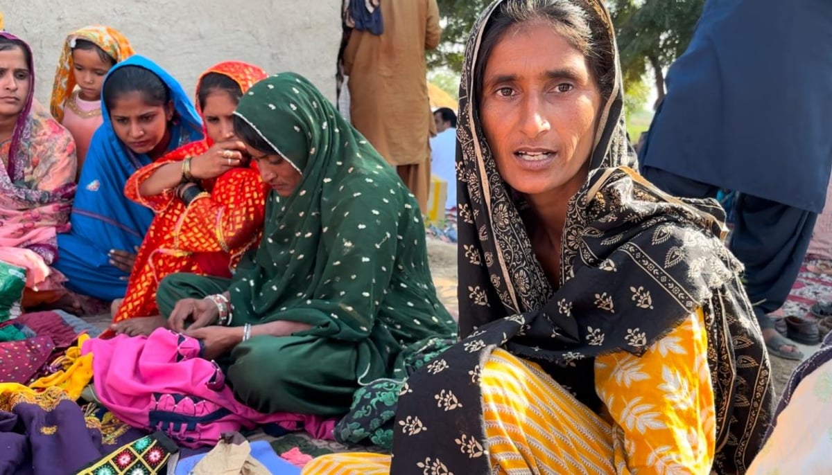 Aami sits alongside other women from her village with her handicraft pieces on display. — Photo by author