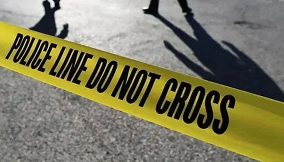 Police officers stand behind crime scene marked with police tape. — AFP/File