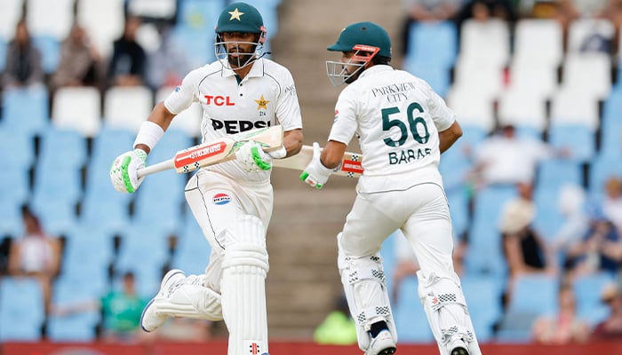 Pakistan´s captain Shan Masood (L) and Pakistan´s Babar Azam (R) run between the wickets during the second day of the first cricket Test match between South Africa and Pakistan at SuperSport Park in Centurion on December 27, 2024. — AFP