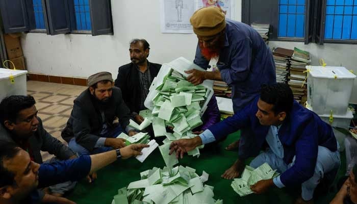 Polling officers count ballot papers during the general election in Karachi, February 8, 2024. — Reuters