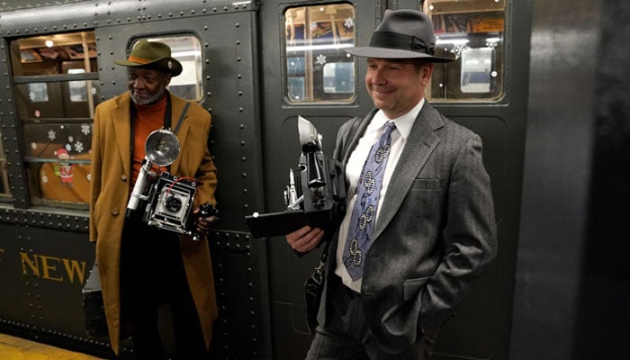 People dressed as old-time press photographers wait to ride the Holiday Nostalgia Train in New York December 8, 2024. — AFP