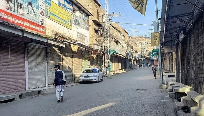 Men walk past a market closed by traders during a strike in District Kurram, Parachinar, Khyber Pakhtunkhwa , on November 22, 2024. — AFP