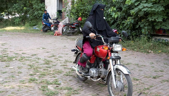 Shumaila Shafiq, 36, a teacher at a private school, rides a motorbike during a motorbike training session as part of the Women on Wheels program organised by the traffic police department in Lahore on October 1, 2024. — Reuters