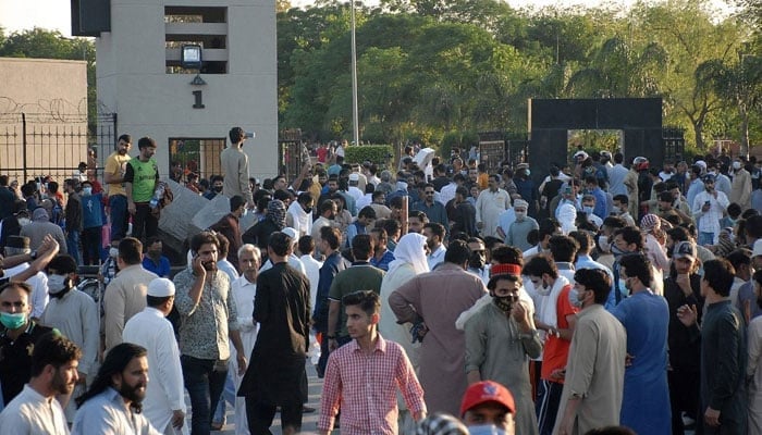 PTI activists and supporters of former prime minister Imran Khan gather in front of the main entrance of General Headquarters in Rawalpindi on May 9, 2023. — AFP