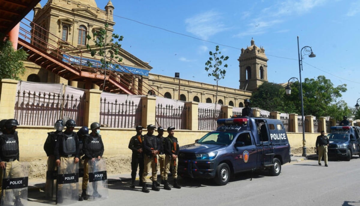 Policemen stand guard outside a polling station during Pakistan’s national elections in Karachi on February 8, 2024. — AFP