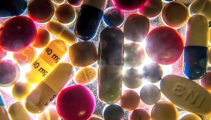 A representational image of several antibiotics laying on a glass surface as light shines overhead. AFP/File