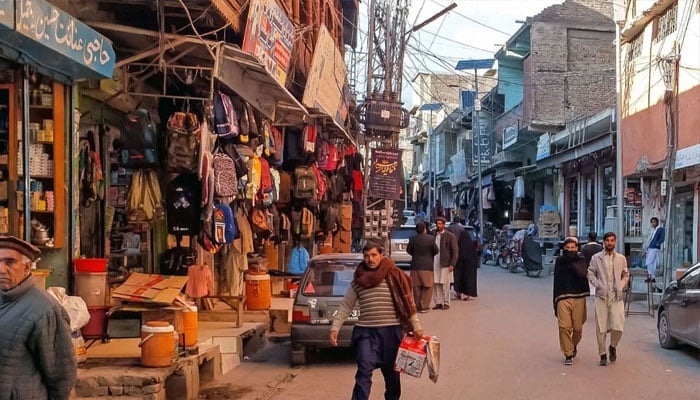 This photograph taken on December 3, 2024, shows local residents walking across a market reopened after clashes in Parachinar, Khyber Pakhtunkhwa province. — AFP